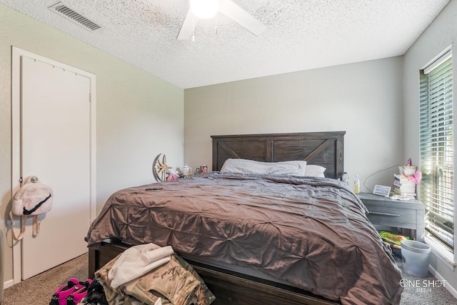 bedroom with ceiling fan, carpet floors, a textured ceiling, and multiple windows