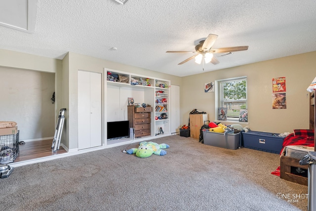 rec room with carpet floors, a textured ceiling, and ceiling fan