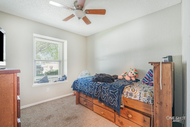 bedroom featuring ceiling fan, light carpet, and a textured ceiling