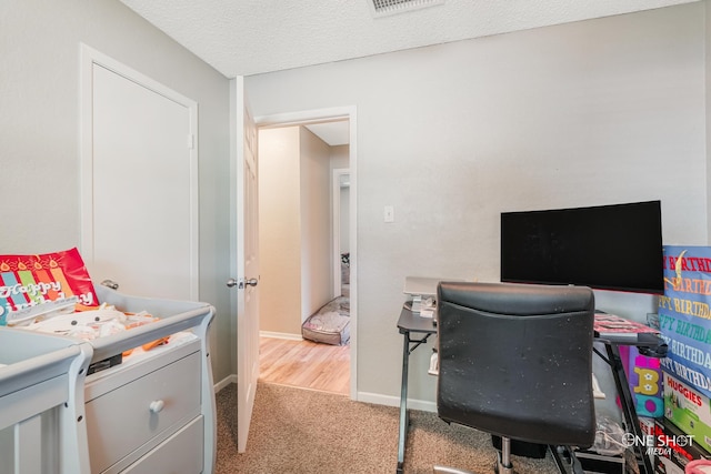 carpeted office space with a textured ceiling