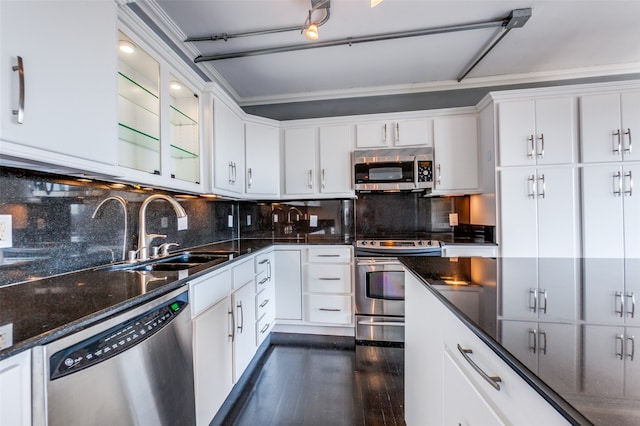 kitchen featuring tasteful backsplash, appliances with stainless steel finishes, sink, white cabinetry, and dark wood-type flooring