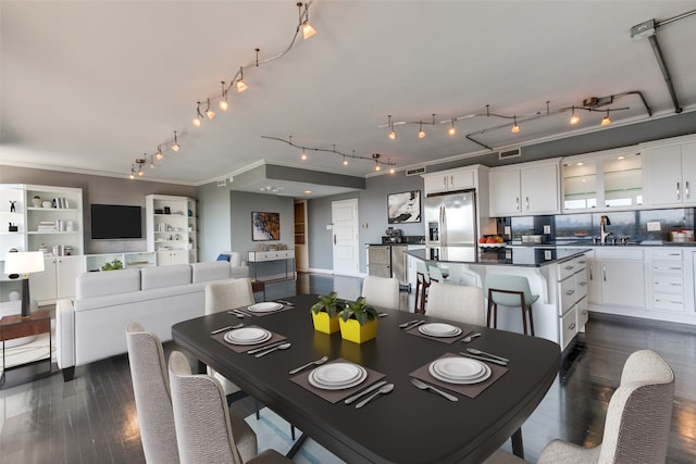 dining area featuring sink, dark wood-type flooring, and ornamental molding