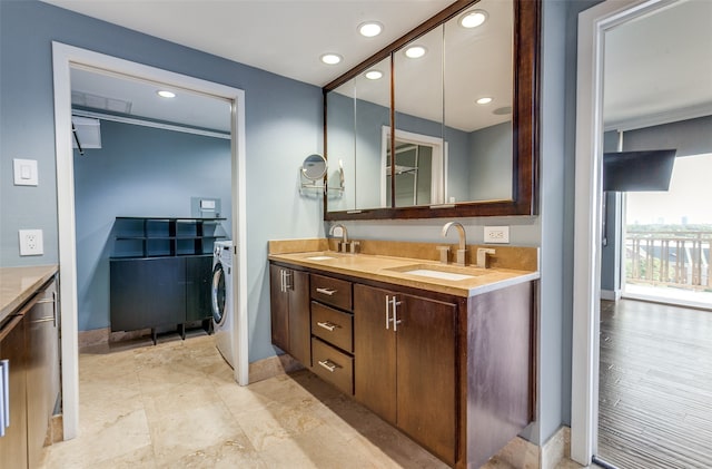 bathroom with vanity, ornamental molding, and washer / dryer