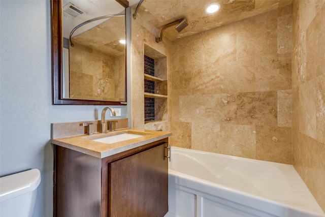 full bathroom featuring toilet, tiled shower / bath, vanity, and built in features