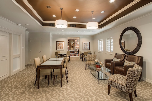 dining room with ornamental molding and a raised ceiling