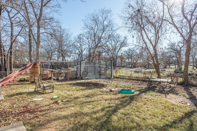 view of yard featuring a playground and a trampoline