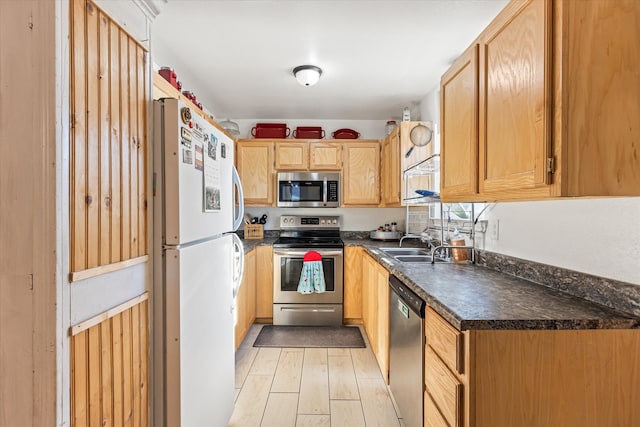 kitchen featuring sink, stainless steel appliances, light brown cabinetry, and light hardwood / wood-style flooring