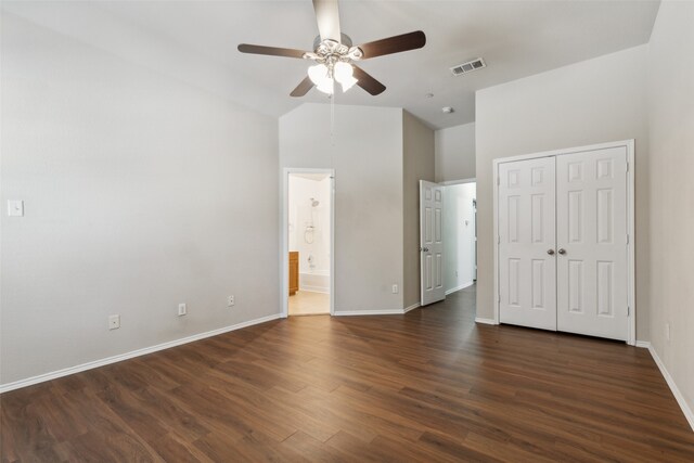 unfurnished bedroom with a closet, ceiling fan, vaulted ceiling, and dark hardwood / wood-style floors