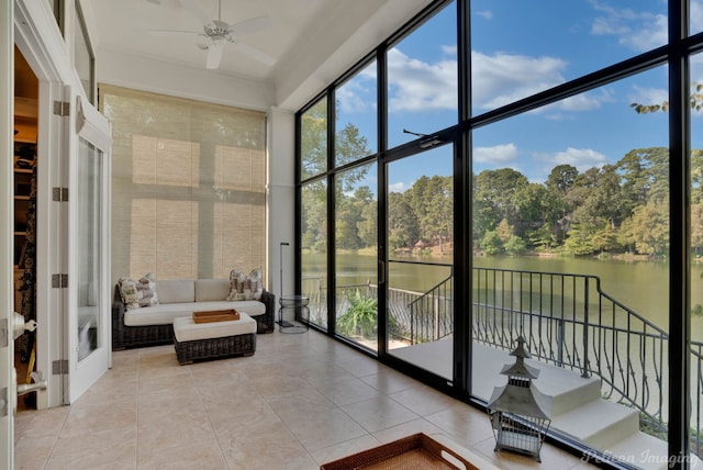 sunroom with a water view and ceiling fan