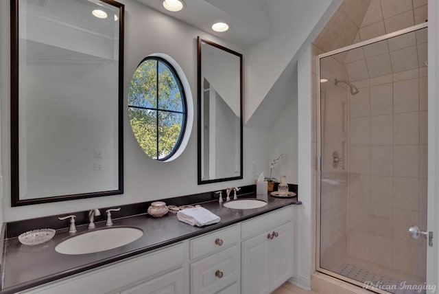 bathroom with a shower with door and vanity