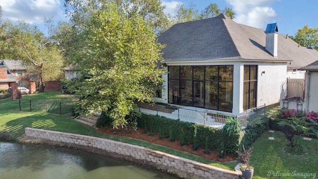 2 Beaux Rivages Dr, Shreveport, LA 71106 - back of house with a chimney, a water view, roof with shingles, a lawn, and fence