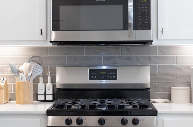 kitchen featuring decorative backsplash, white cabinets, and appliances with stainless steel finishes