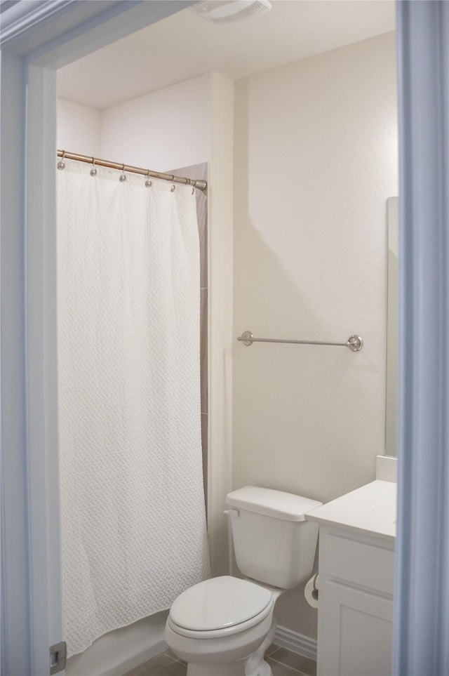 bathroom with tile patterned flooring, vanity, and toilet