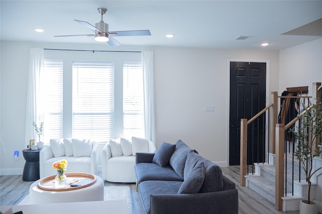 living room with ceiling fan and light hardwood / wood-style flooring