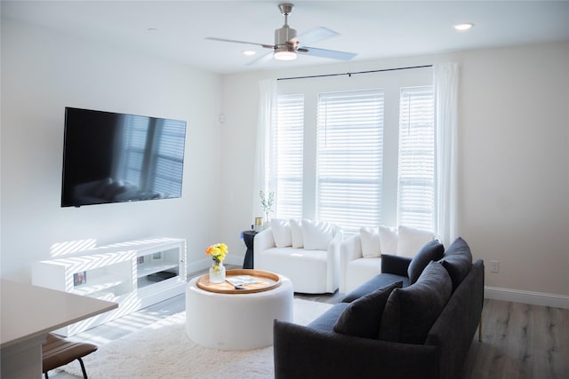 living room featuring hardwood / wood-style floors and ceiling fan