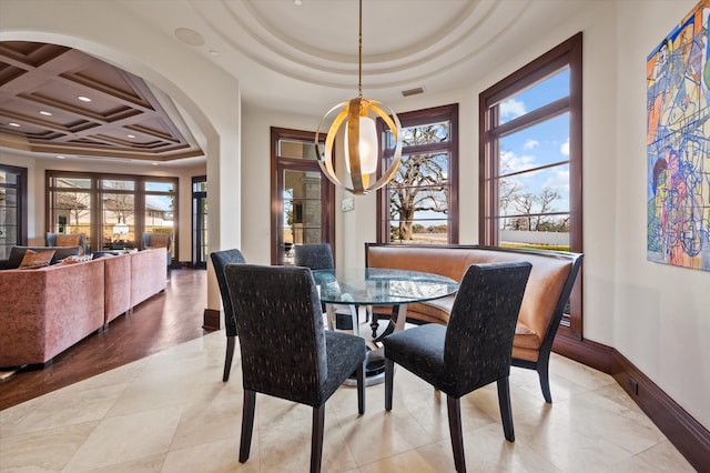 dining room featuring coffered ceiling, beam ceiling, light tile patterned floors, and a healthy amount of sunlight