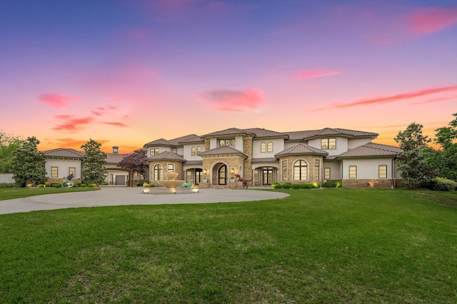 mediterranean / spanish house featuring a yard and french doors