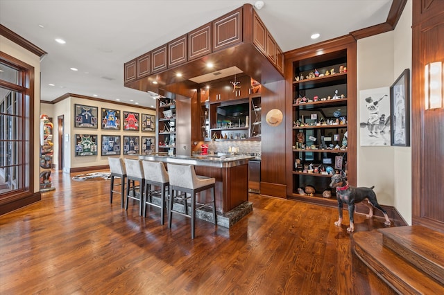 bar featuring dishwasher, dark hardwood / wood-style floors, crown molding, and decorative backsplash