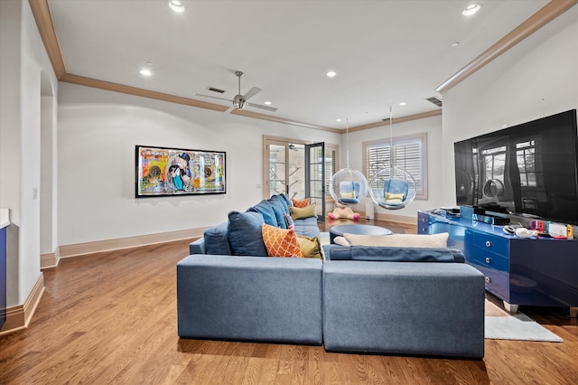 living room with ceiling fan, light wood-type flooring, and crown molding