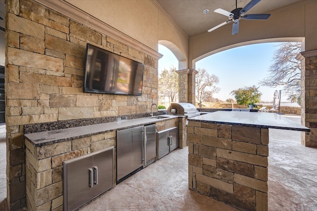 view of patio featuring ceiling fan, grilling area, an outdoor kitchen, and sink