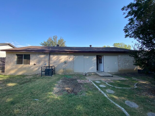 rear view of property featuring a yard and a patio area