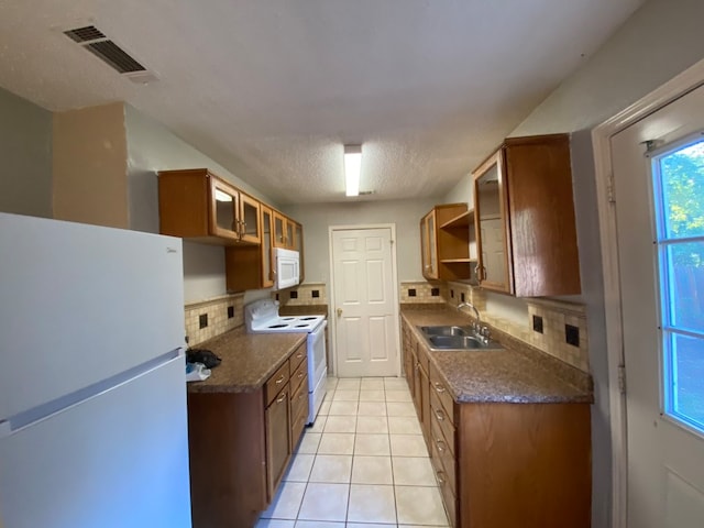 kitchen with light tile patterned floors, sink, white appliances, tasteful backsplash, and a textured ceiling