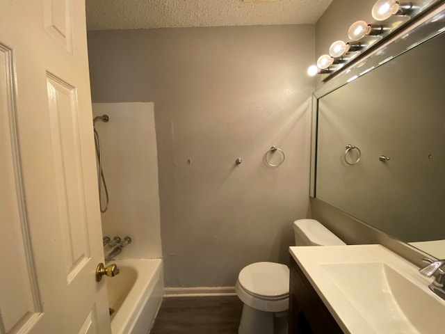 full bathroom featuring toilet, shower / bathing tub combination, hardwood / wood-style flooring, vanity, and a textured ceiling