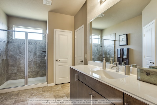 bathroom featuring a shower with door and vanity