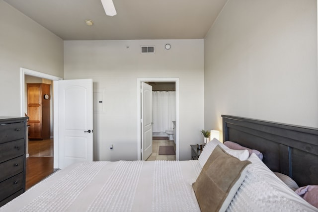 bedroom with ceiling fan, connected bathroom, and wood-type flooring