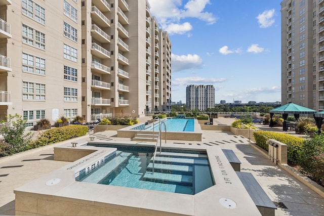 view of pool with a hot tub