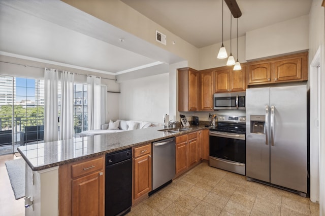 kitchen featuring dark stone countertops, sink, stainless steel appliances, kitchen peninsula, and hanging light fixtures