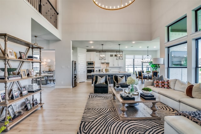 living room with light hardwood / wood-style flooring and a towering ceiling