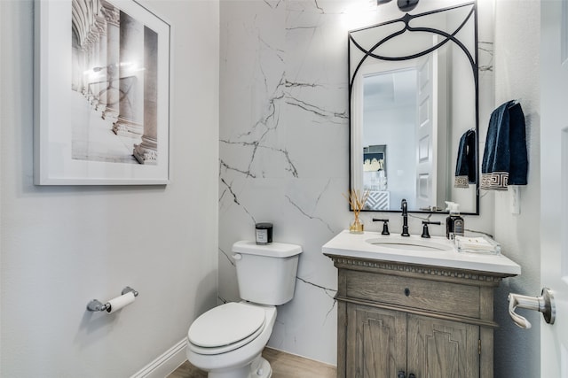 bathroom with hardwood / wood-style floors, toilet, and vanity