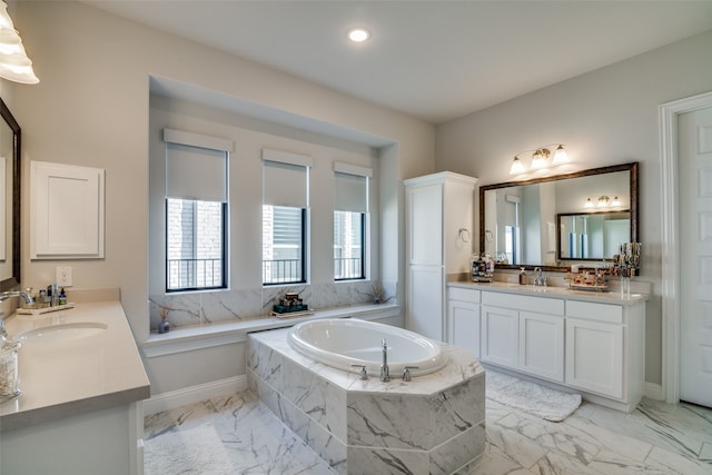 bathroom featuring tiled tub and vanity