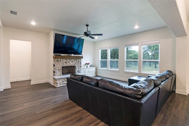 living room featuring a fireplace, ceiling fan, dark hardwood / wood-style floors, and a textured ceiling