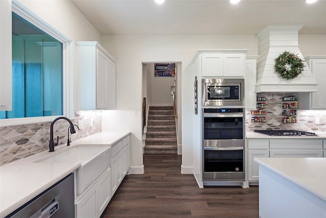 kitchen featuring decorative backsplash, dark hardwood / wood-style flooring, sink, stainless steel appliances, and white cabinets