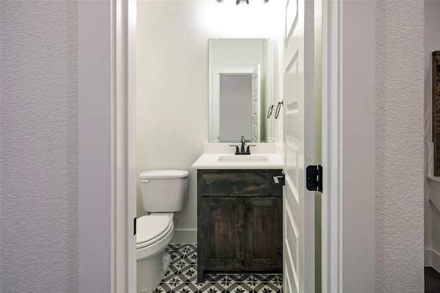 bathroom with vanity, tile patterned flooring, and toilet