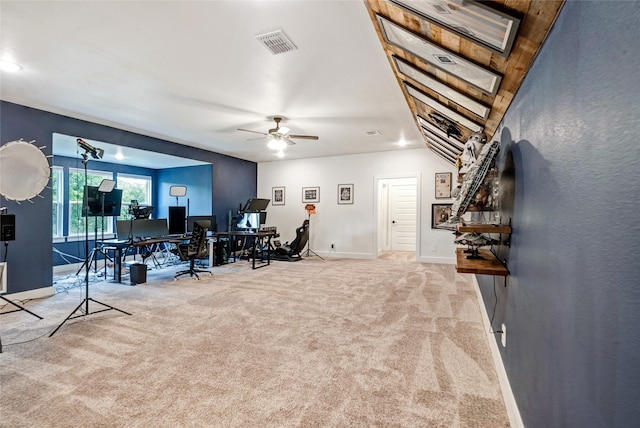 carpeted living room with ceiling fan and vaulted ceiling