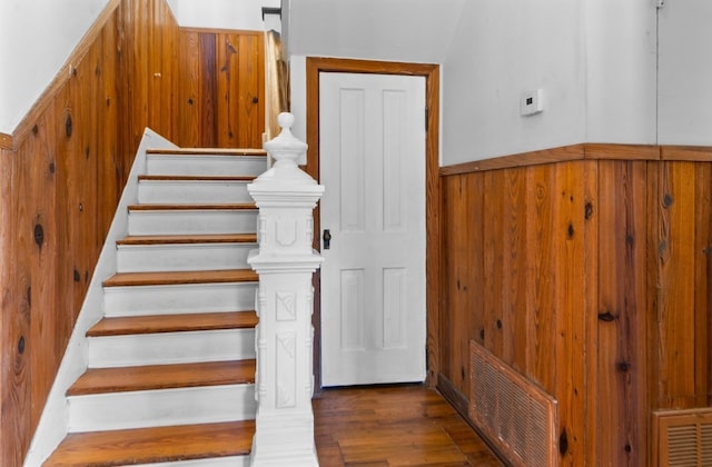 stairs featuring hardwood / wood-style flooring and wood walls