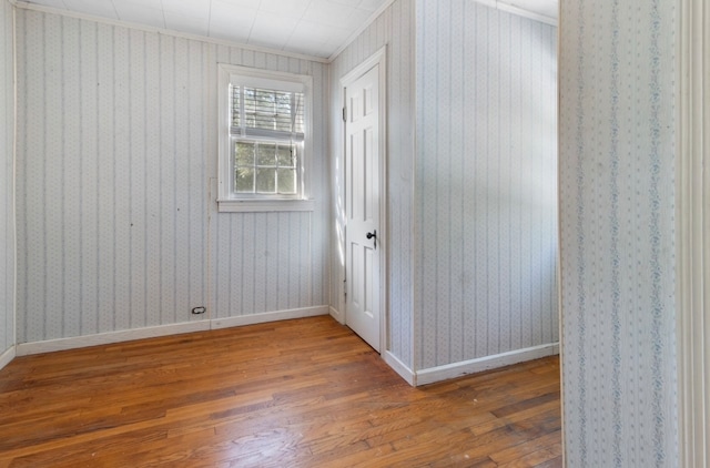 unfurnished room featuring wood-type flooring and ornamental molding