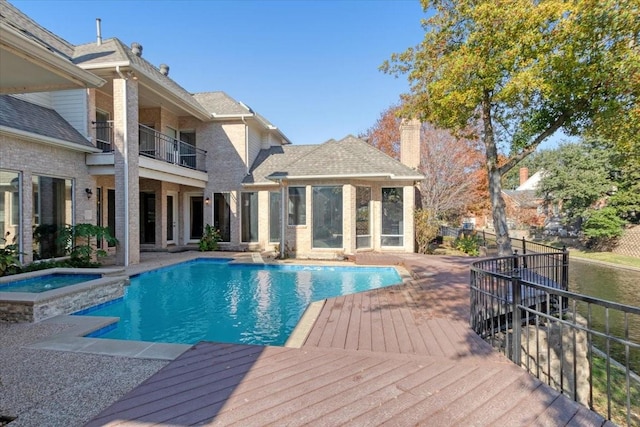 view of pool with a deck and an in ground hot tub