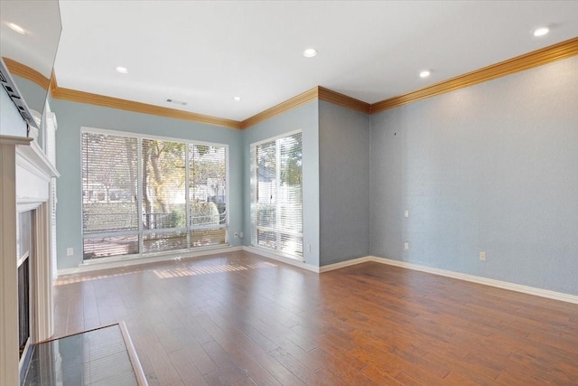 unfurnished living room featuring hardwood / wood-style flooring and crown molding