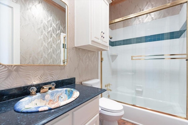 full bathroom with vanity, shower / bath combination with glass door, and toilet