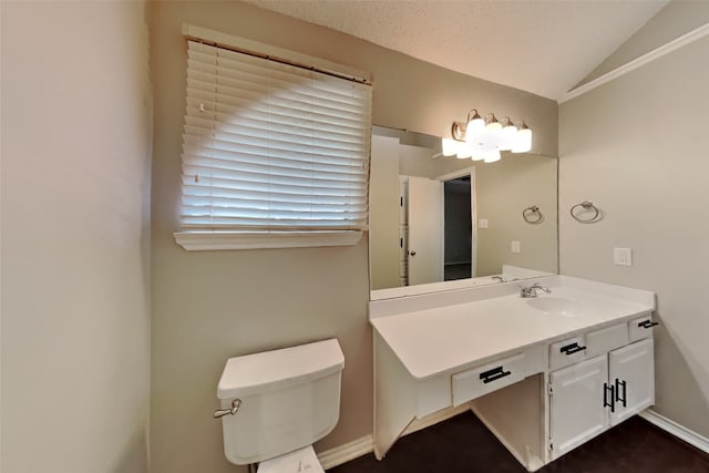 bathroom with lofted ceiling, a textured ceiling, vanity, and toilet