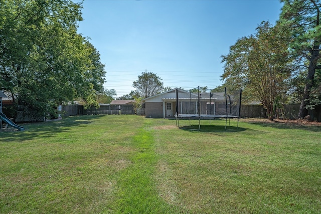 view of yard with a playground and a trampoline