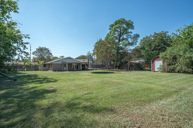 view of yard featuring a trampoline and a storage shed