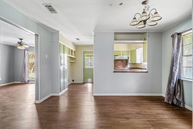 spare room with ceiling fan with notable chandelier, crown molding, dark hardwood / wood-style flooring, and a wealth of natural light