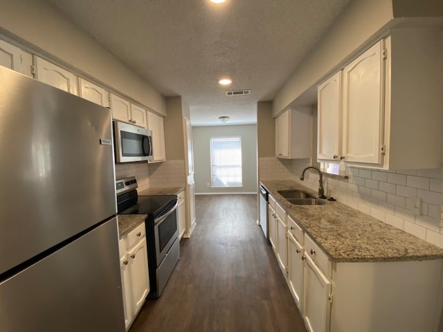 kitchen with sink, dark hardwood / wood-style flooring, white cabinetry, appliances with stainless steel finishes, and a textured ceiling