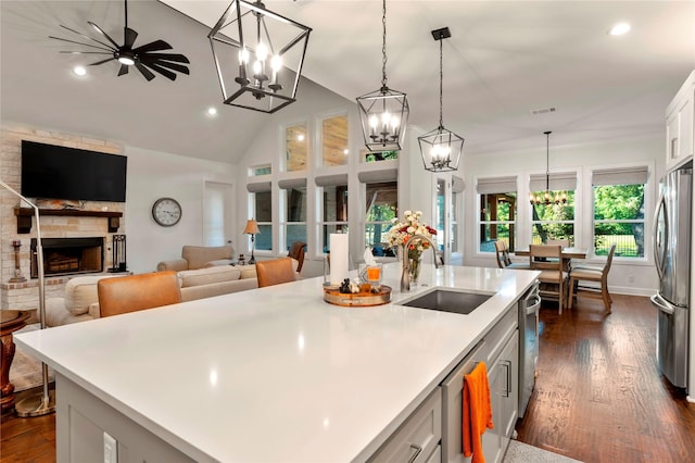 kitchen featuring stainless steel appliances, sink, pendant lighting, and a kitchen island with sink