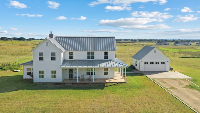 view of front of home with a front yard, a garage, an outdoor structure, and covered porch